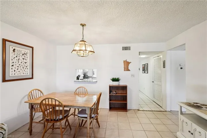 Dining space featuring a textured ceiling and light tile patterned floors