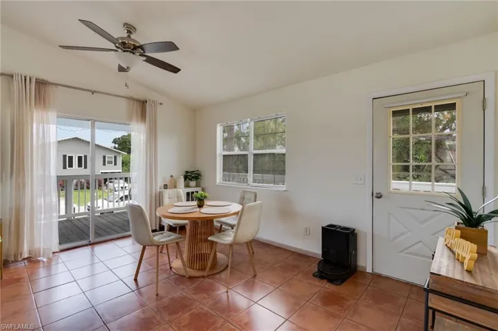 Interior space featuring terracotta-style tile flooring, white walls, and a ceiling fan with integrated lighting