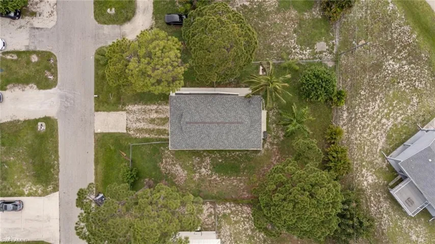 Single-story residence with a shingle roof and surrounding green spaces