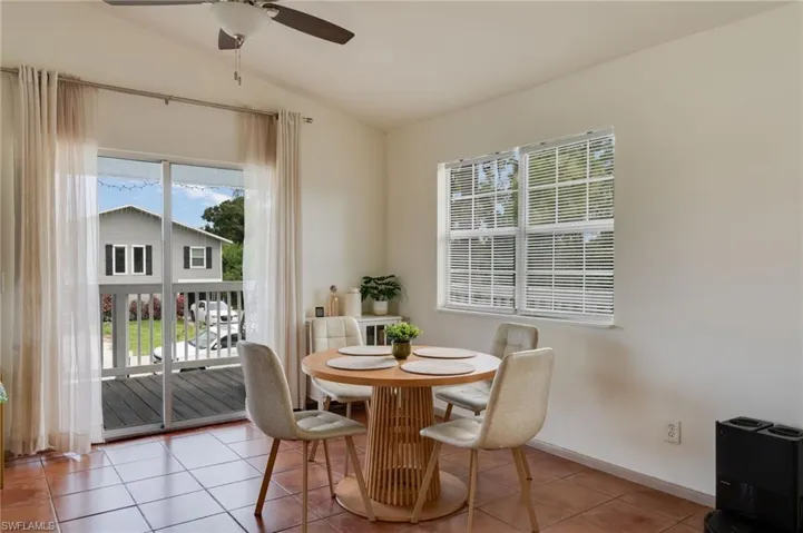 Dining area featuring tile flooring, a ceiling fan, and ample natural light from a window and glass sliding door