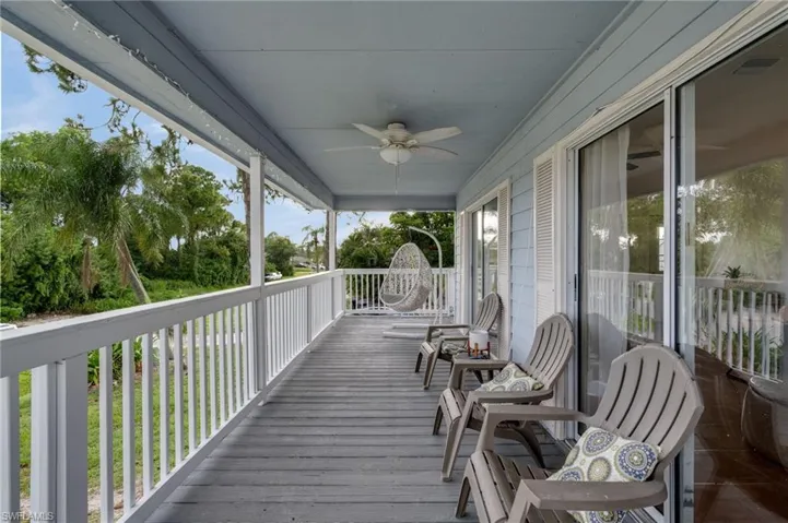 Covered outdoor porch featuring wood-finish flooring and a ceiling fan