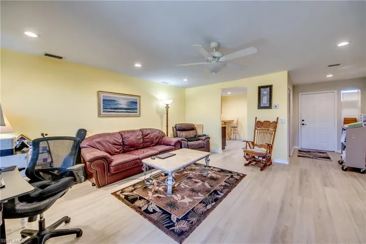 Living room with light wood-type flooring and ceiling fan