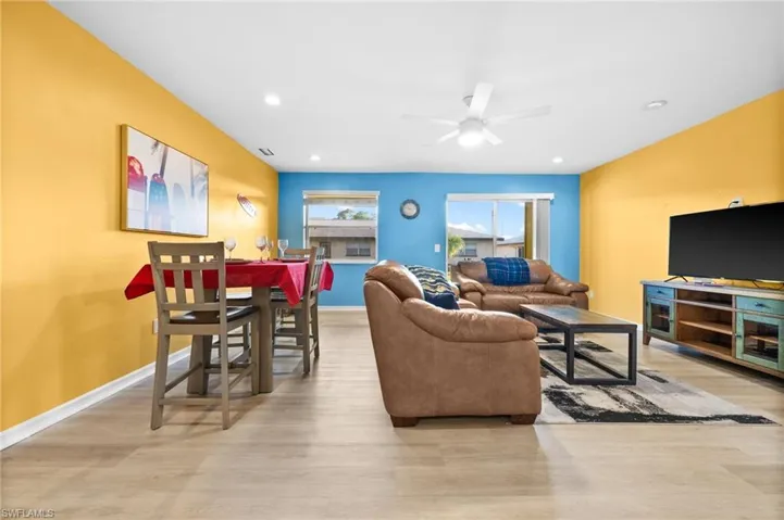Living room with light hardwood / wood-style floors and ceiling fan