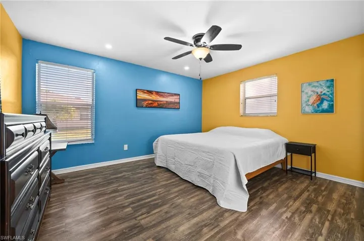 Bedroom with ceiling fan and dark wood-type flooring