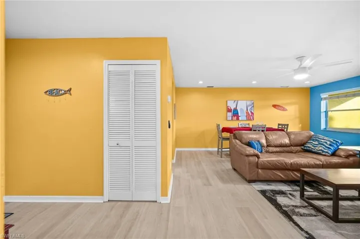 Living room with ceiling fan and light hardwood / wood-style floors