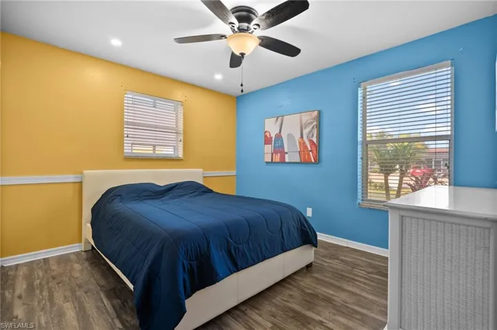 Bedroom with ceiling fan and dark wood-type flooring
