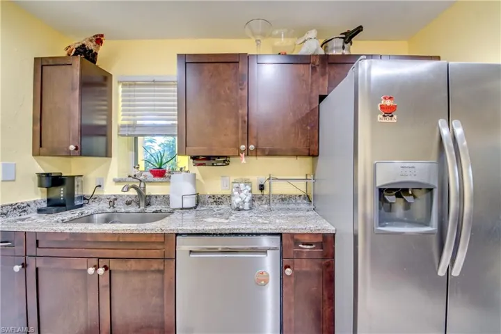 Kitchen featuring light stone countertops, sink, and stainless steel appliances