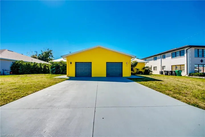 View of front of home featuring a front lawn and a garage
