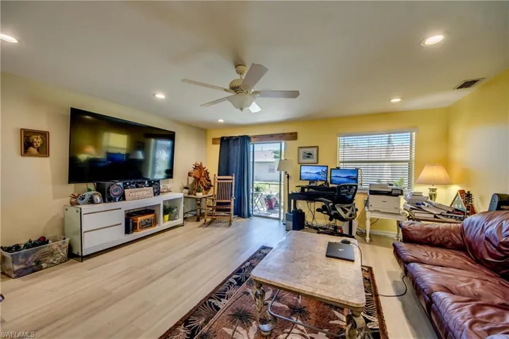 Living room with ceiling fan and light hardwood / wood-style floors