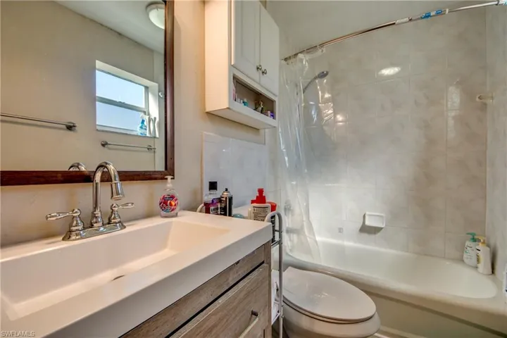 Full bathroom with shower / bath combo, toilet, and vanity