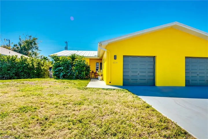 Single story home featuring a garage and a front yard