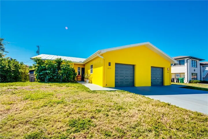 Single story home featuring a front yard and a garage