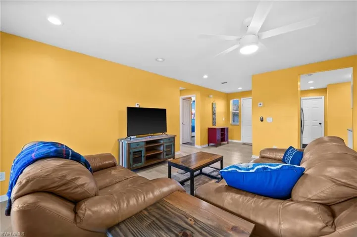 Living room with ceiling fan and light hardwood / wood-style floors