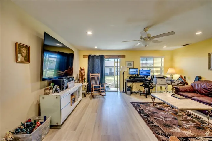 Living room with ceiling fan and light hardwood / wood-style flooring
