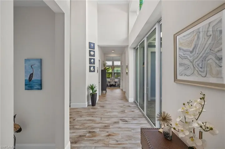 Hallway featuring light hardwood / wood-style flooring and a towering ceiling