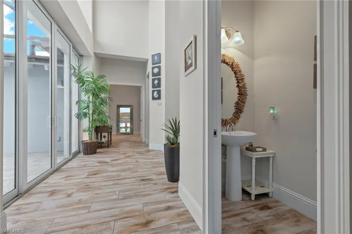 Hall with light wood-type flooring and french doors