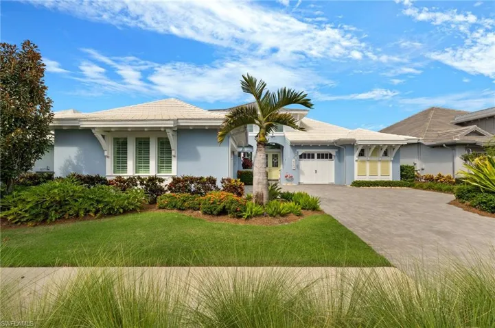Single story home featuring a garage and a front lawn