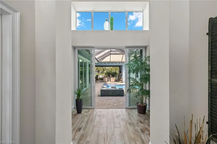 Foyer entrance with light wood-type flooring and a towering ceiling