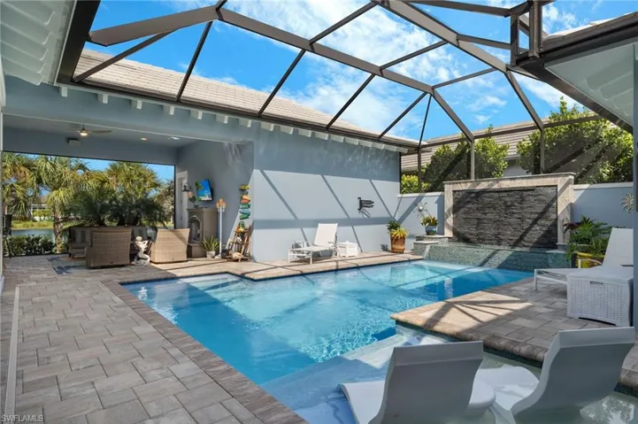 View of swimming pool featuring a patio and a lanai