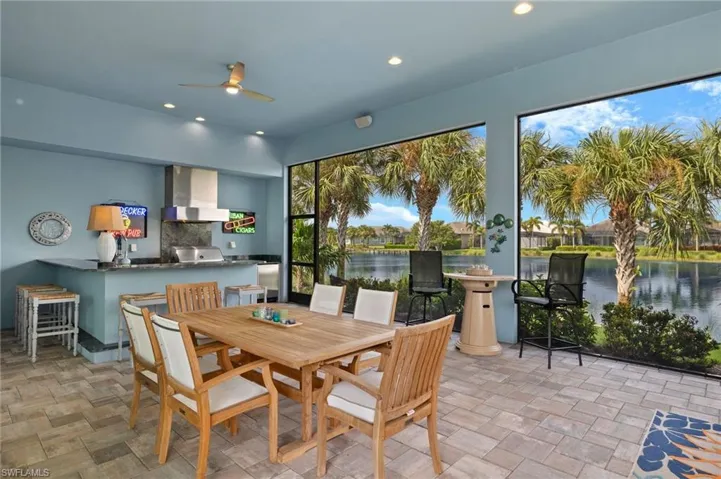 Dining area with light tile patterned flooring, a water view, and ceiling fan