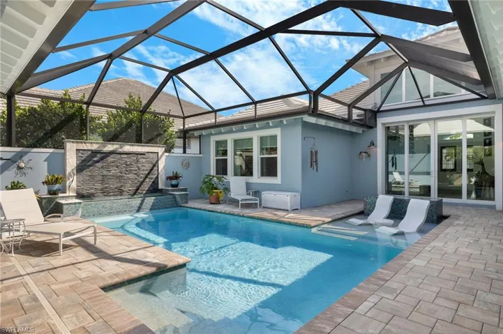 View of pool with a lanai, pool water feature, and a patio area