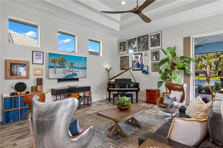 Living room with ceiling fan, ornamental molding, plenty of natural light, and hardwood / wood-style floors