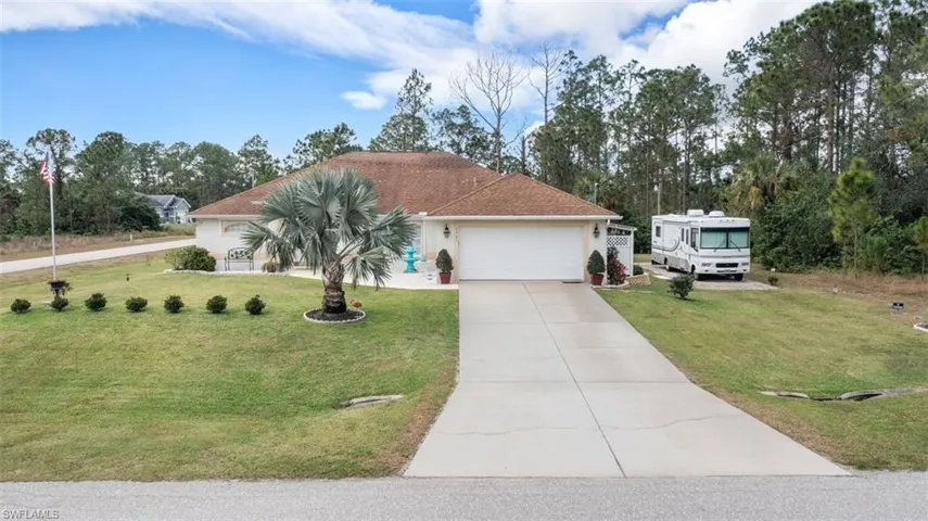 Ranch-style home with a front yard and a garage