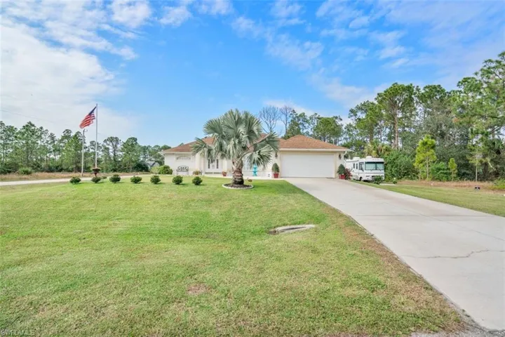 View of front of home featuring a garage and a front lawn