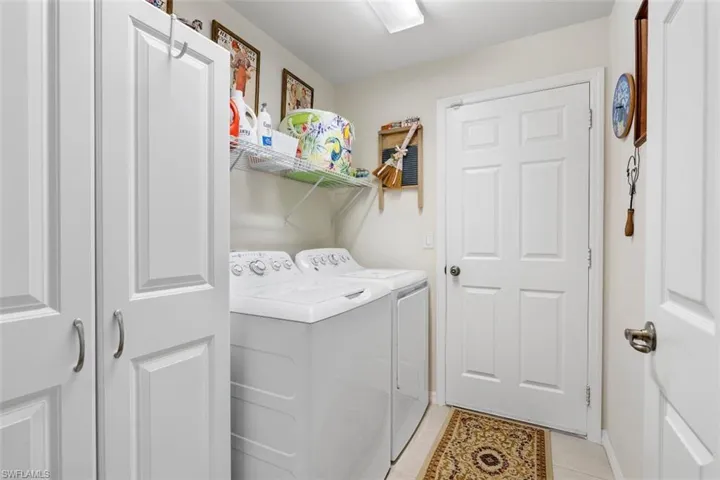 Laundry room with light tile patterned flooring and separate washer and dryer