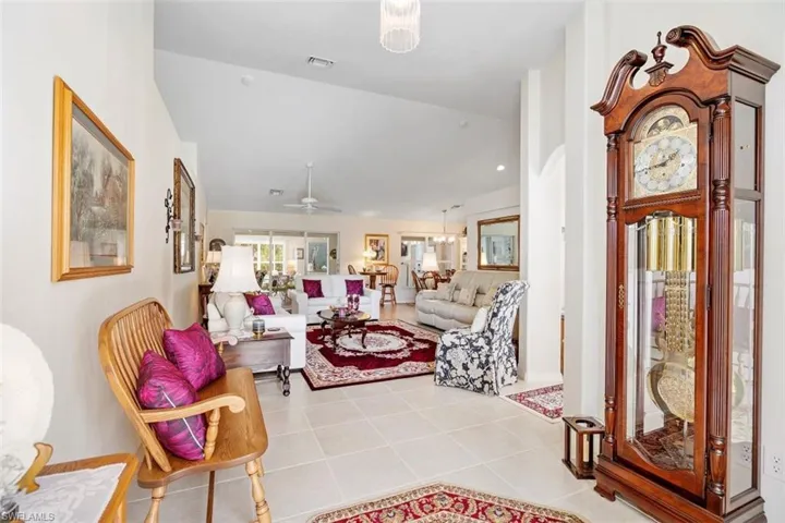 Tiled foyer entrance featuring ceiling fan and vaulted ceiling