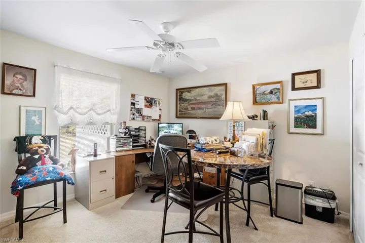 Carpeted office space featuring ceiling fan