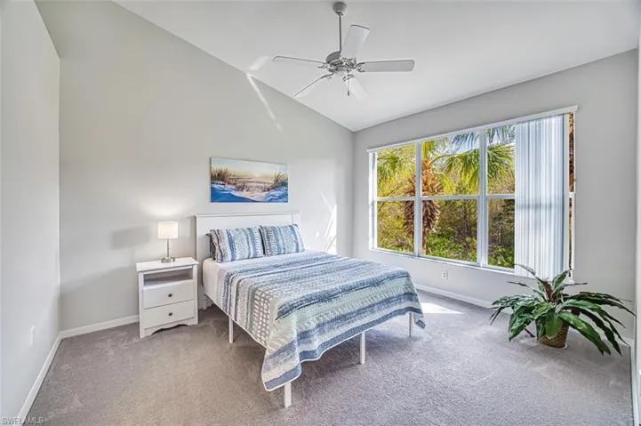 Bedroom featuring carpet flooring, ceiling fan, and vaulted ceiling