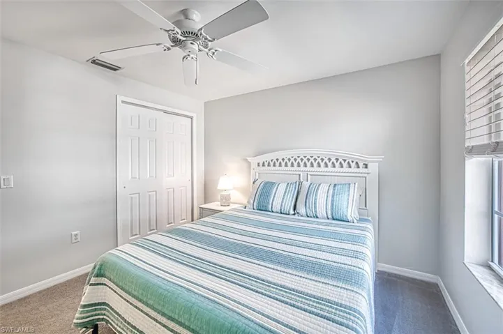 Carpeted bedroom featuring a closet and ceiling fan
