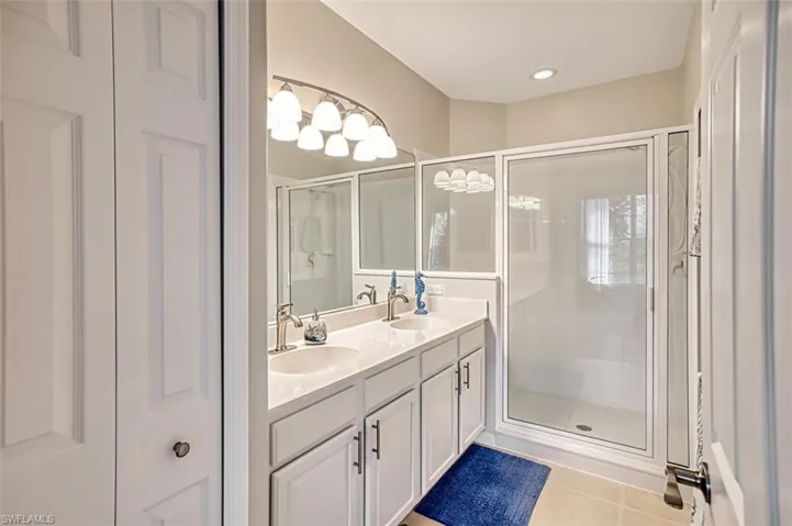 Bathroom with tile patterned flooring, vanity, and a shower with shower door