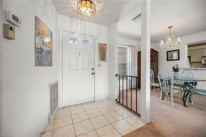 Entry foyer with tiled flooring and a decorative ceiling light fixture