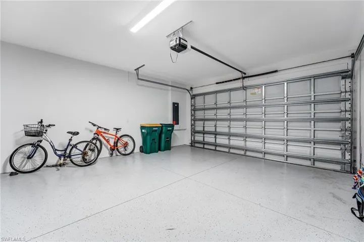 Garage featuring a garage door opener and electric panel