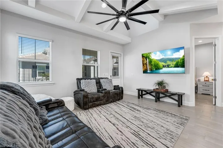 Living room featuring light wood finished floors, ceiling fan, recessed lighting, and beamed ceiling