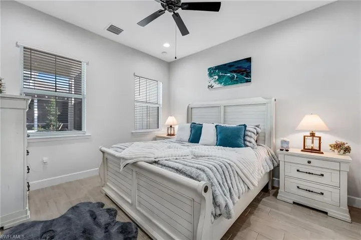 Bedroom with light wood-style floors, ceiling fan, and recessed lighting