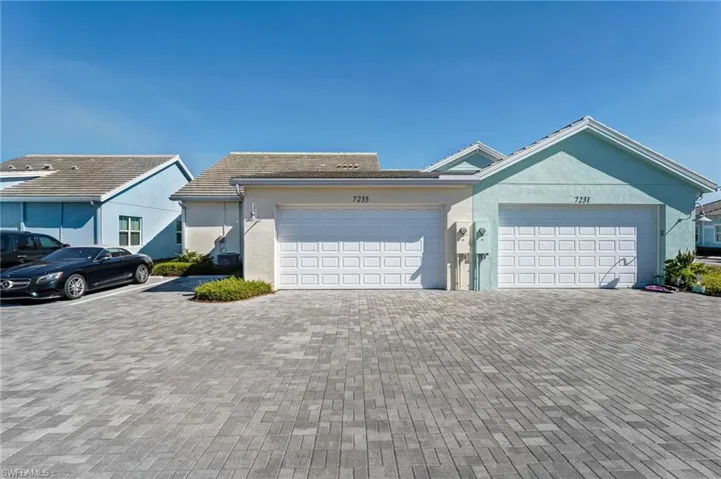 Ranch-style house with stucco siding, decorative driveway, and a tiled roof