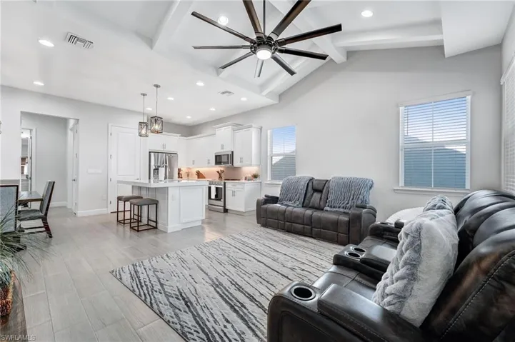 Living area featuring recessed lighting, a ceiling fan, light wood-type flooring, and a chandelier
