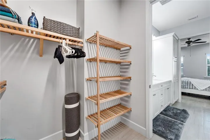 Spacious closet featuring ceiling fan and light wood finished floors