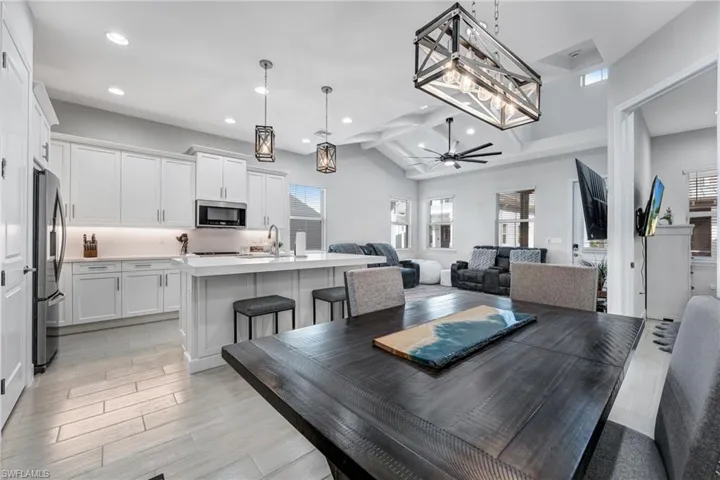 Dining area featuring a ceiling fan, light wood finished floors, beam ceiling, and recessed lighting
