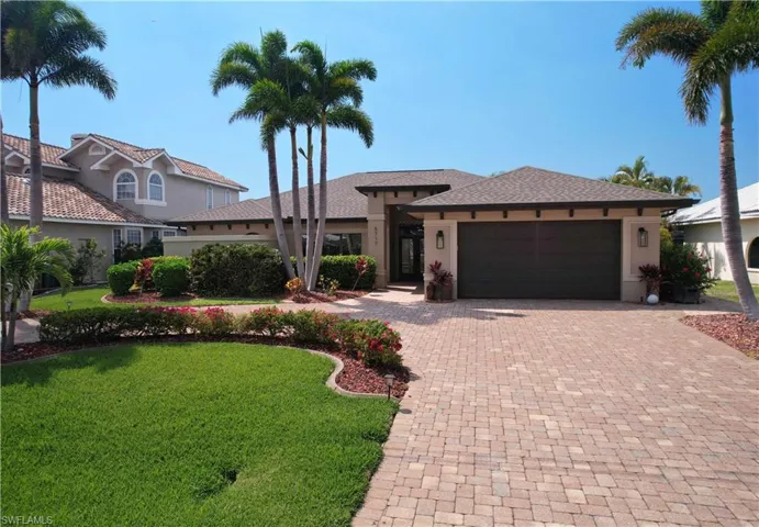 View of front of home with stucco siding, an attached garage, decorative driveway, and a front yard