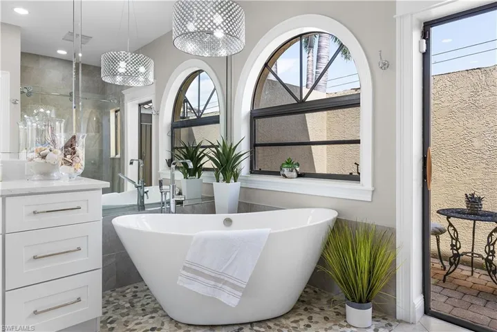 Bathroom featuring a freestanding tub, a sink, a shower stall, and double vanity