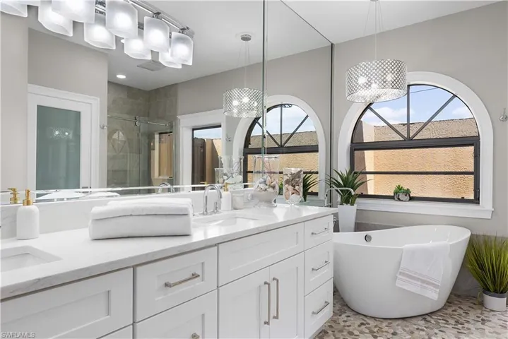 Full bath featuring recessed lighting, visible vents, vanity, a freestanding tub, and a stall shower
