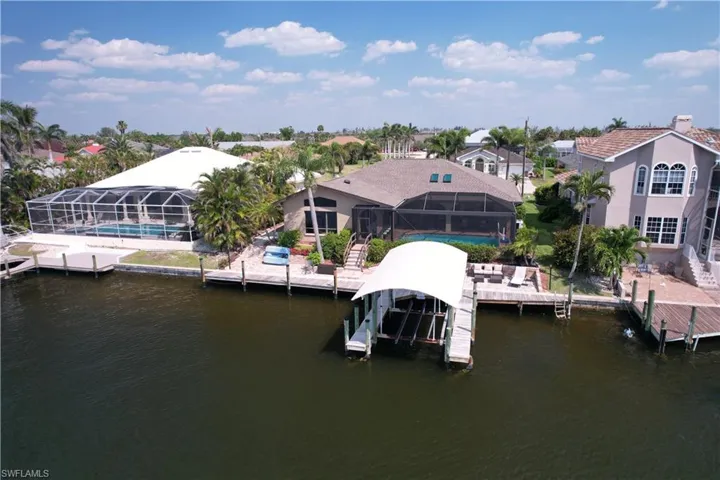 View of dock with an outdoor pool, a lanai, and a water view