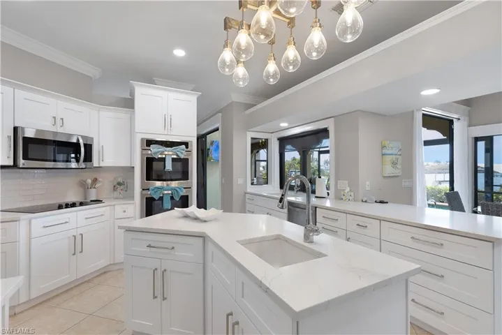 Kitchen featuring white cabinets, light stone countertops, and stainless steel appliances