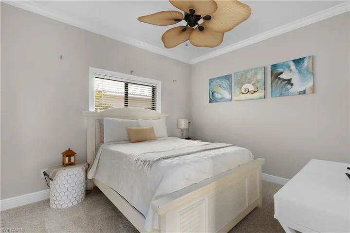 Bedroom featuring multiple closets, visible vents, crown molding, baseboards, and ceiling fan
