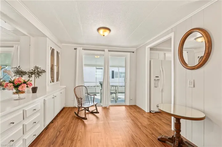 Sitting room with wood-type flooring and ornamental molding