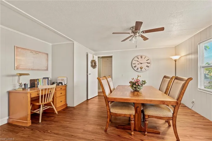 Dining space featuring ceiling fan, crown molding, and light hardwood / wood-style flooring